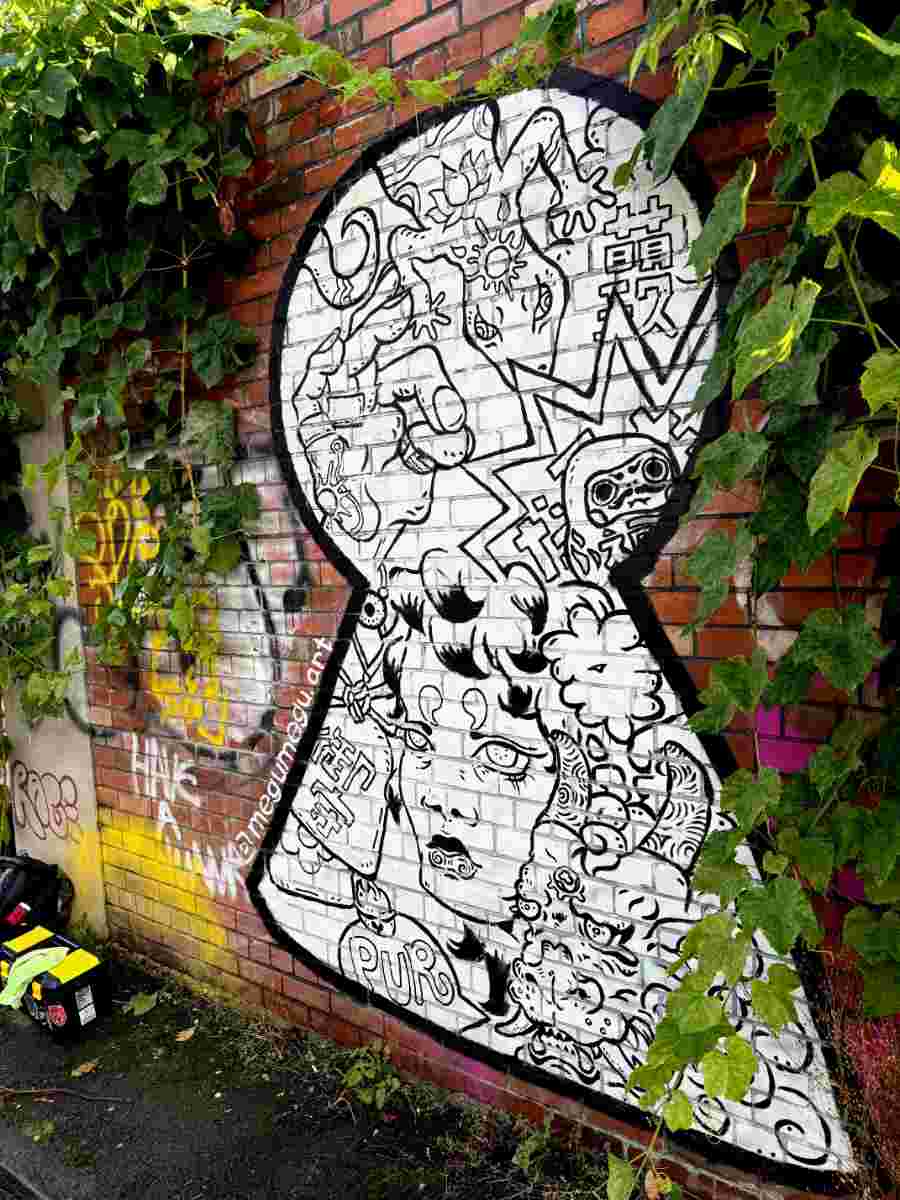 Full image of hand painted mural on brick. Featuring a dragon, a woman, a daruma and talismans.