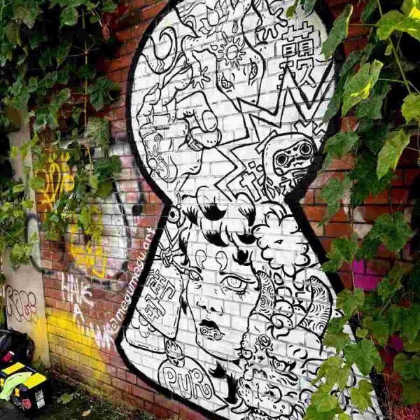 Full image of hand painted mural on brick. Featuring a dragon, a woman, a daruma and talismans.